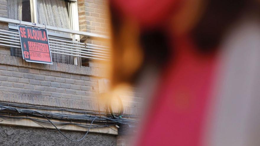 Una mujer pasa por delante de una vivienda con el cartel de ‘Se alquila’.