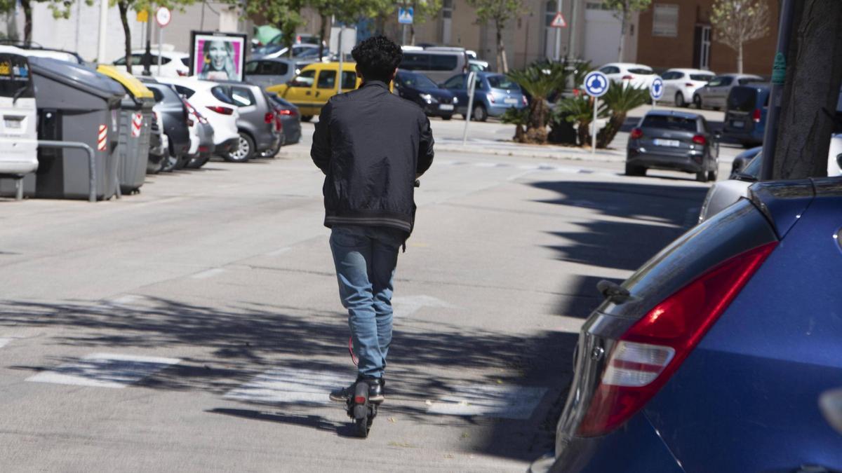 Un hombre circula en patinete por Gandia