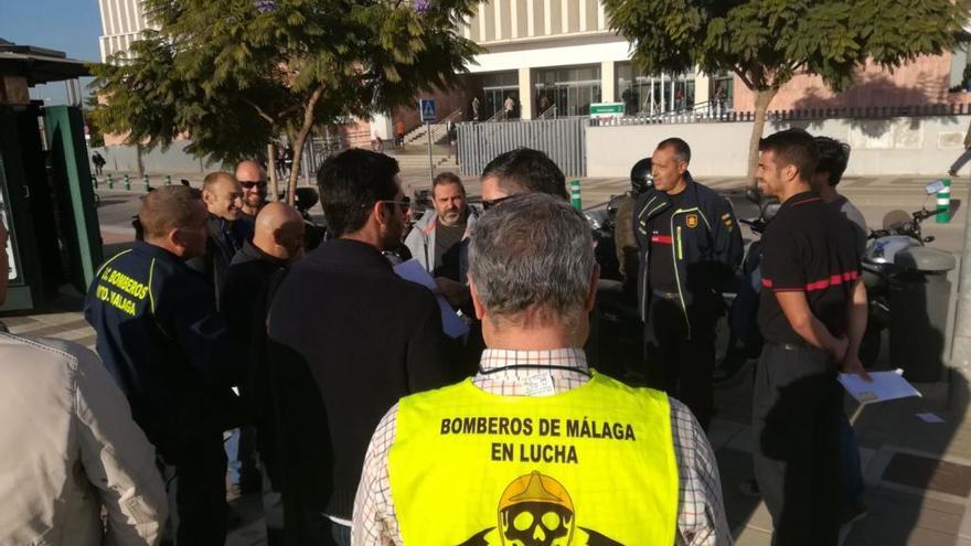 Un grupo de bomberos ante la Ciudad de la Justicia.