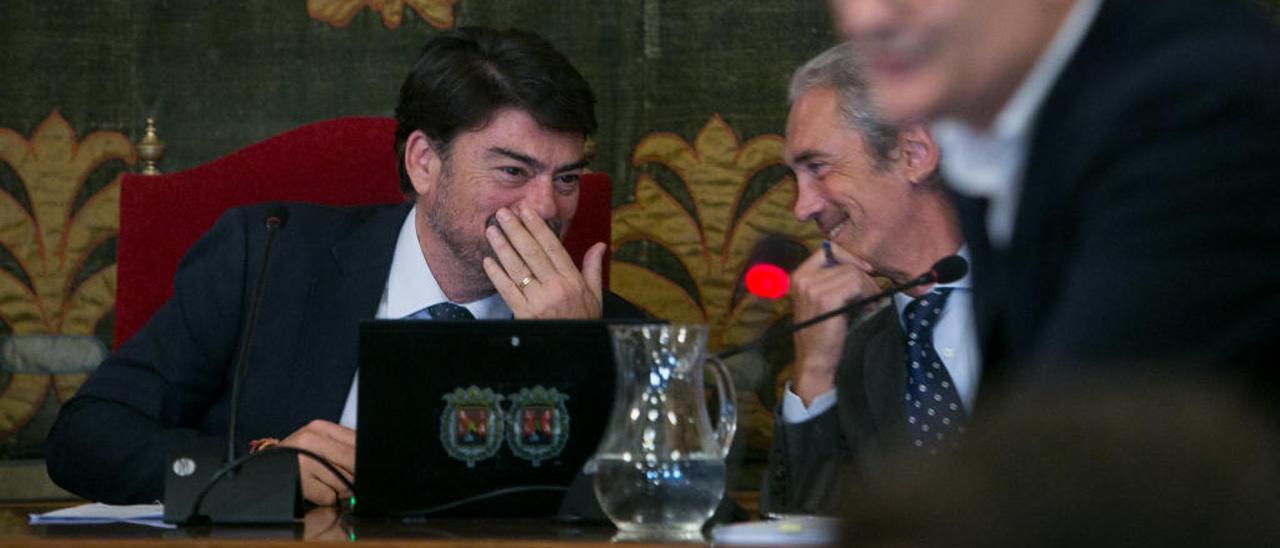 El alcalde conversa con el secretario, durante una intervención del socialista Sanguino en un pleno.