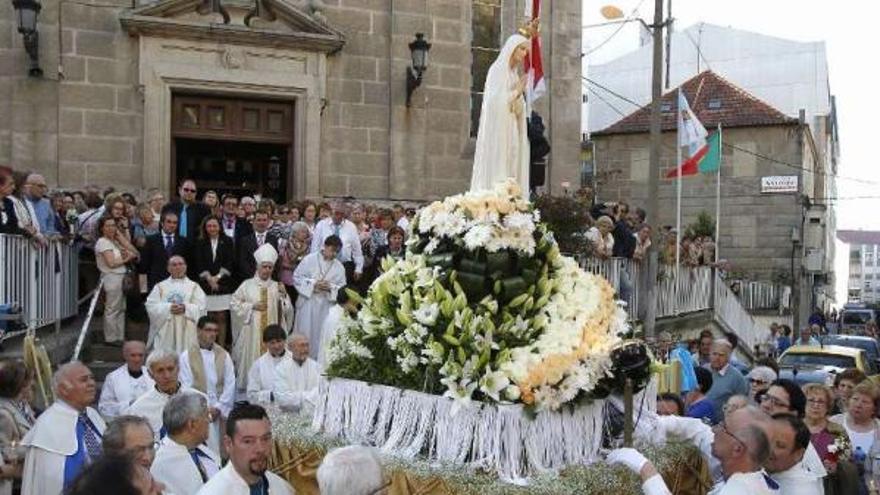 La Virgen, a su salida del templo de Fátima para iniciar la procesión, entre fieles.  // FOTOS: J. Lores