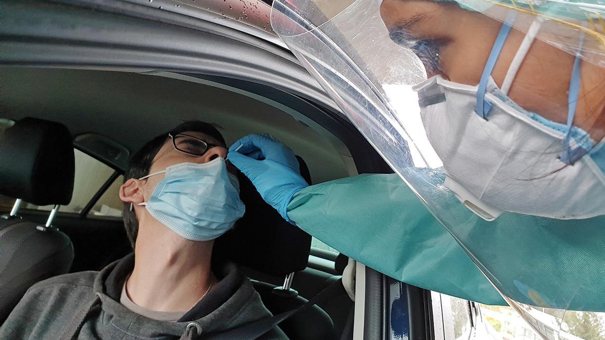 Un sanitario realiza una PCR a un joven en el covidauto de Vigo