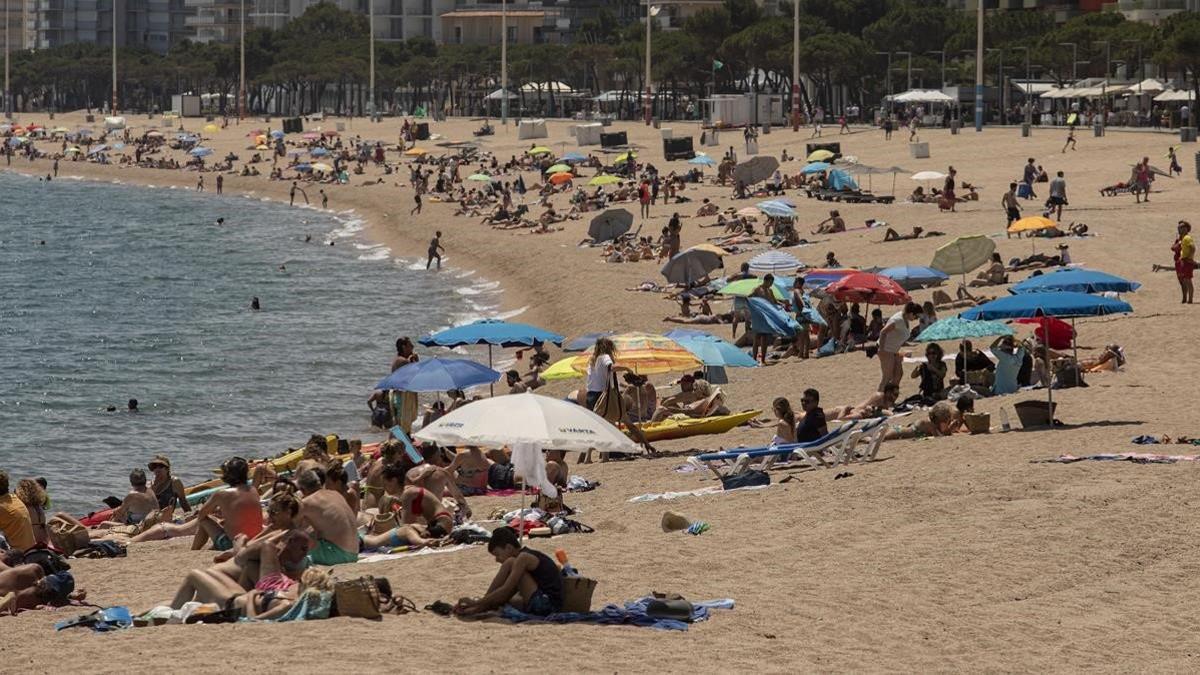 Bañistas disfrutan del primer día de libertad de movimiento en la playa grande de Platja d'Aro, el 20 de junio del 2020