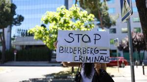 MADRID, 30/05/2024.- Una mujer sostiene una pancarta a las puertas del hotel de Madrid donde desde hoy jueves, cientos de representantes del más alto nivel del mundo empresarial, financiero, político y académico de Europa y EEUU se dan cita en la septuagésima Reunión Bilderberg.