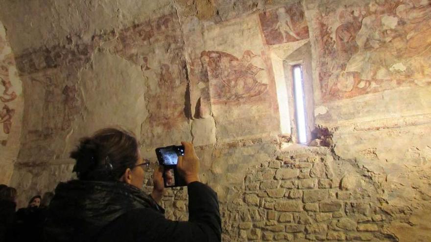 En la imagen superior una mujer saca una fotografía de los murales restaurados. Sobre estas líneas, Menchu Álvarez del Valle, abuela de la Reina Letizia, durante la inauguración.