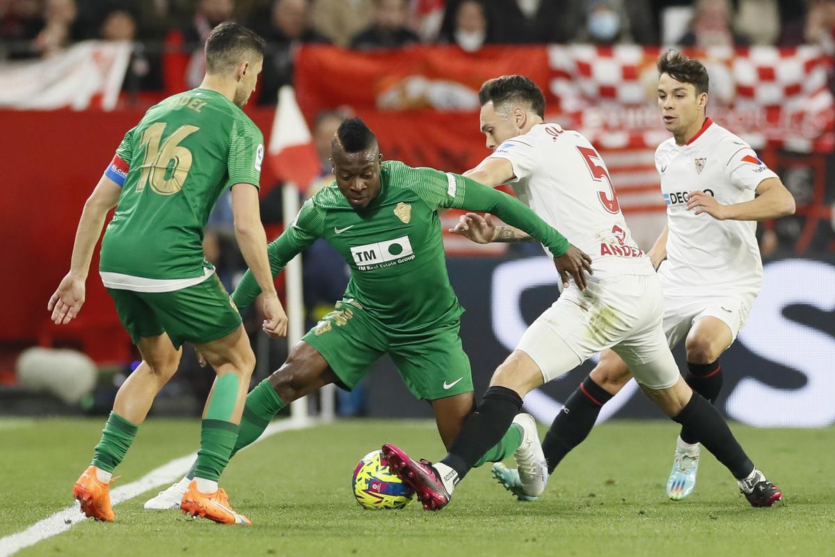 Sevilla, 28/01/2023.- El delantero argentino del Sevilla Lucas Ocampos (2d) lucha con el colombiano Helibelton Palacios (2i), del Elche, durante el encuentro correspondiente a la jornada 19 que Sevilla FC y Elche CF disputan hoy sábado en el estadio Sánchez-Pizjuán, en Sevilla. EFE/José Manuel Vidal.