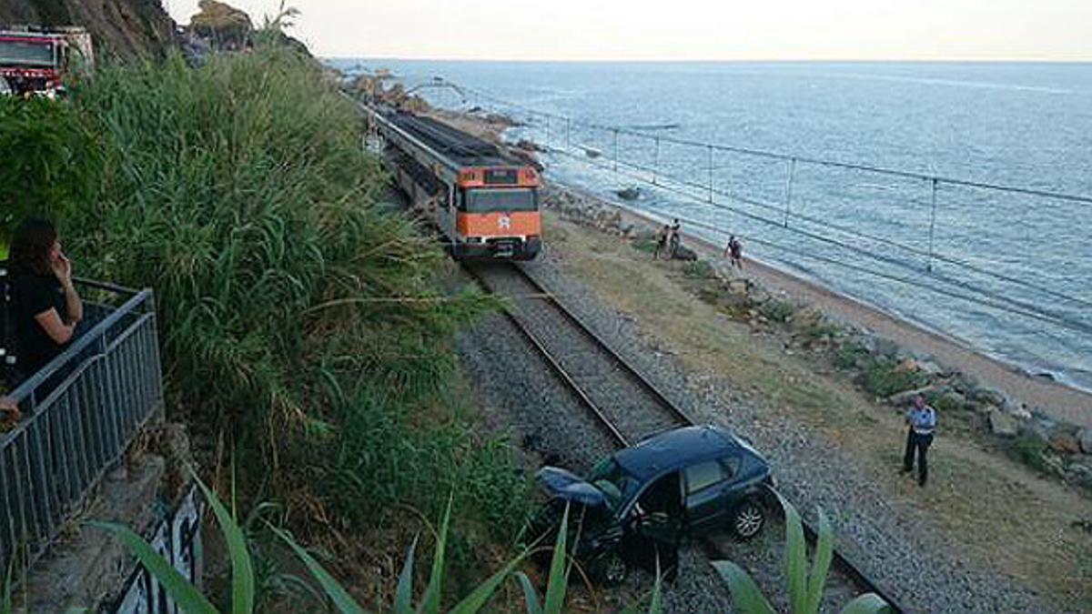 El coche caído entre las vías.