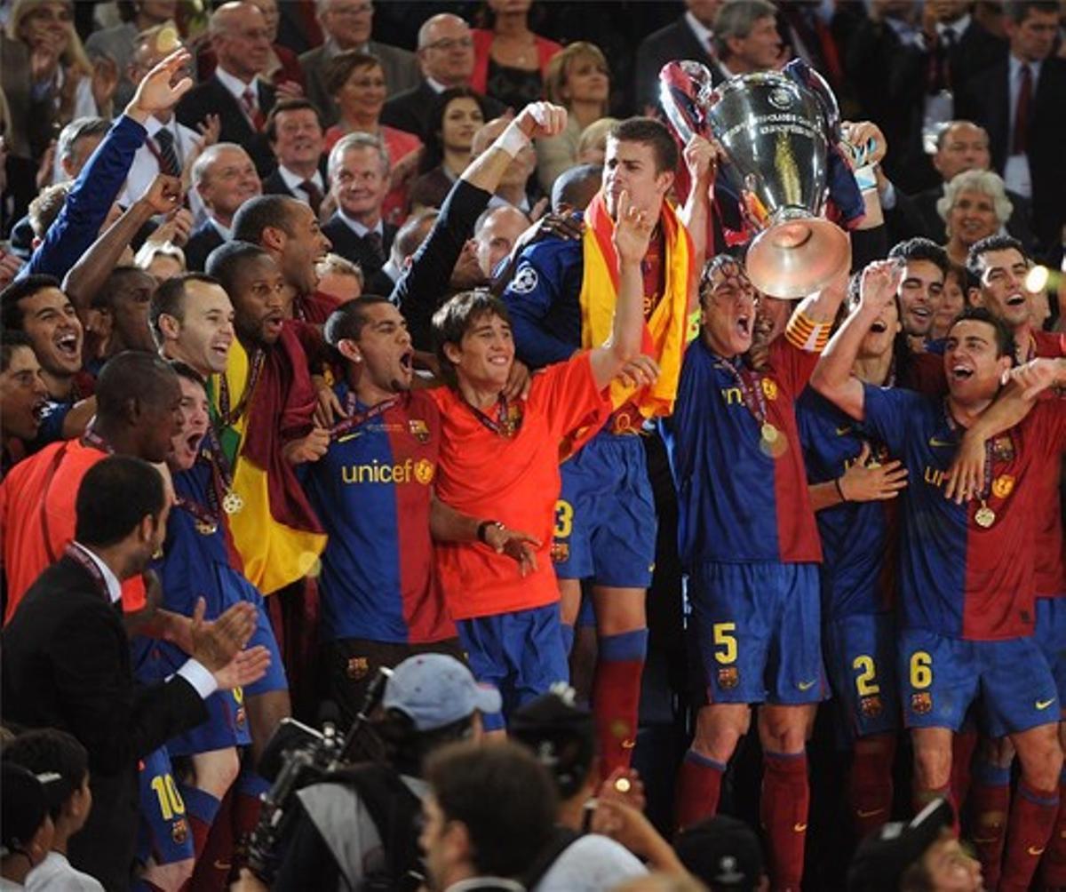 Puyol levanta el trofeo rodeado por sus eufóricos compañeros.
