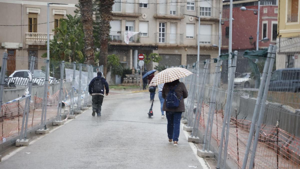 Poca gente por las calles de una Paiporta lluviosa.