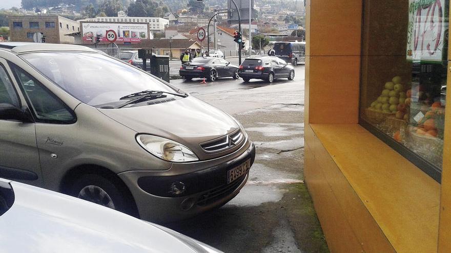 El vehículo en el que viajaban los detenidos, a la izquierda.