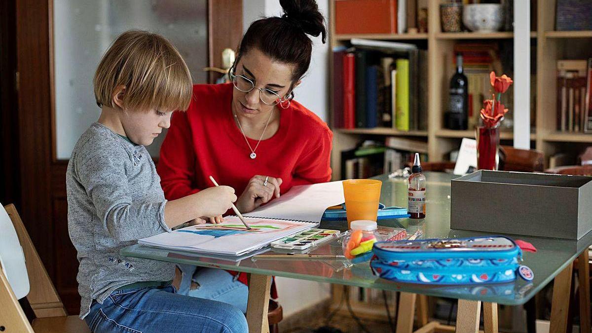 Una madre teletrabajadora ayuda a su hijo con los deberes.