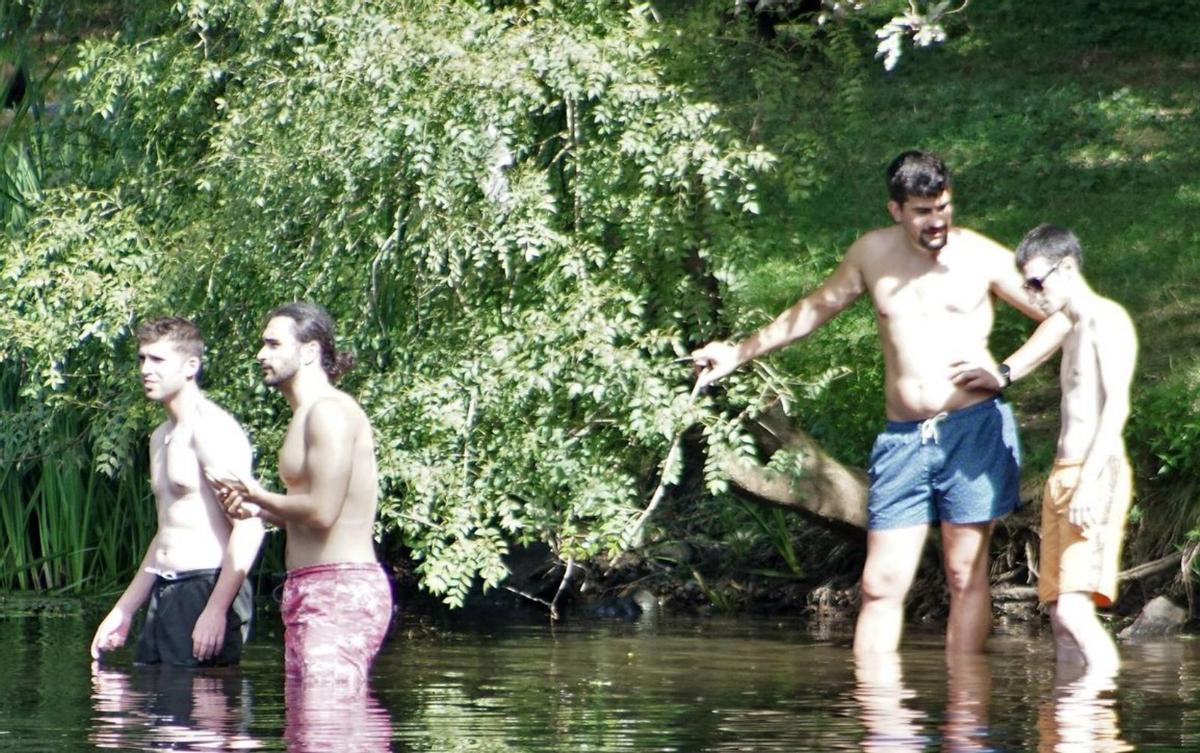 Un grupo de bañistas, ayer, en la playa fluvial de Chaián /Jesús PRIETO