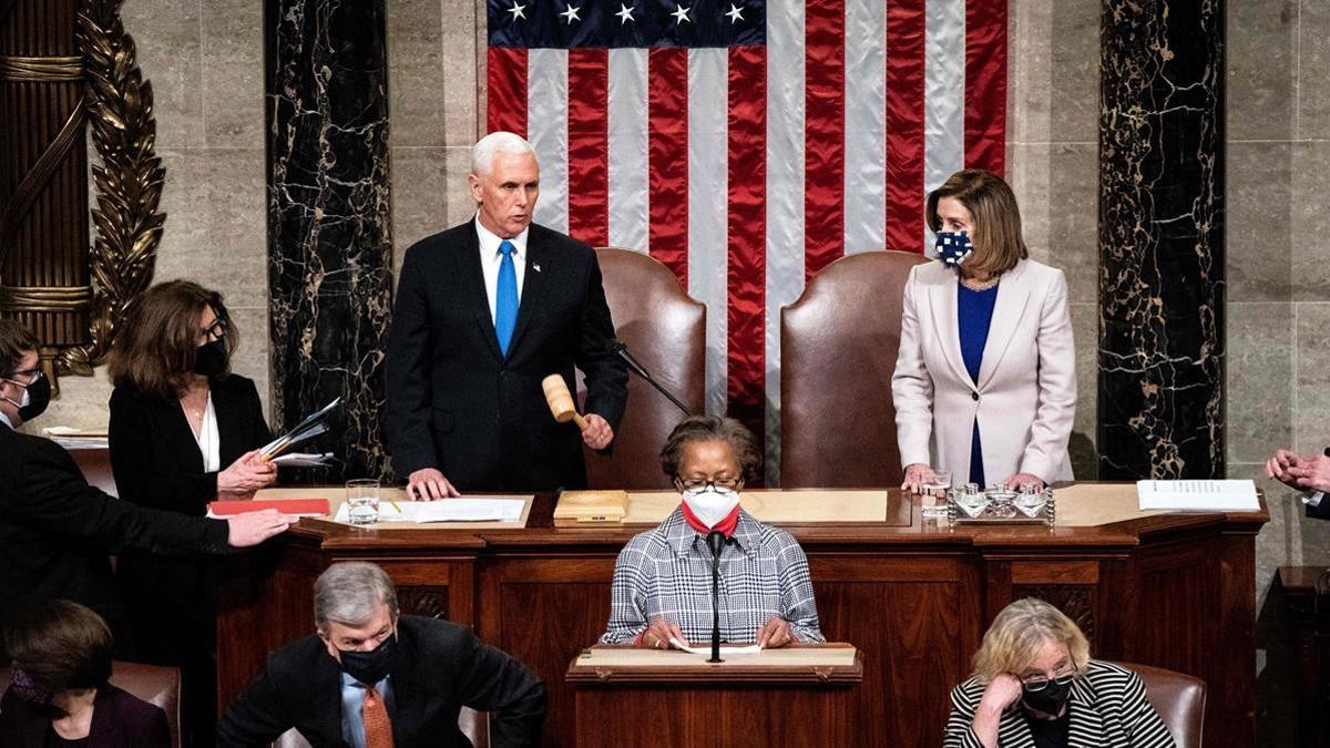 La presidenta de la Cámara de Representantes de EEUU., Nancy Pelosi (d), y el vicepresidente de Estados Unidos, Mike Pence tras retomar la sesión en el Congreso.