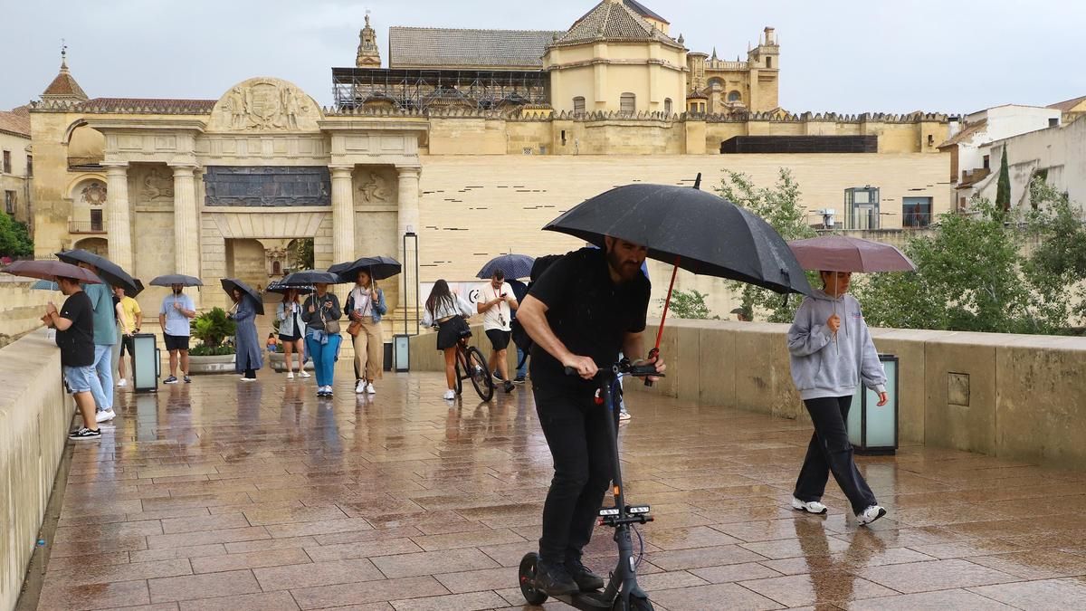 Viandantes con paraguas en el Puente Romano.