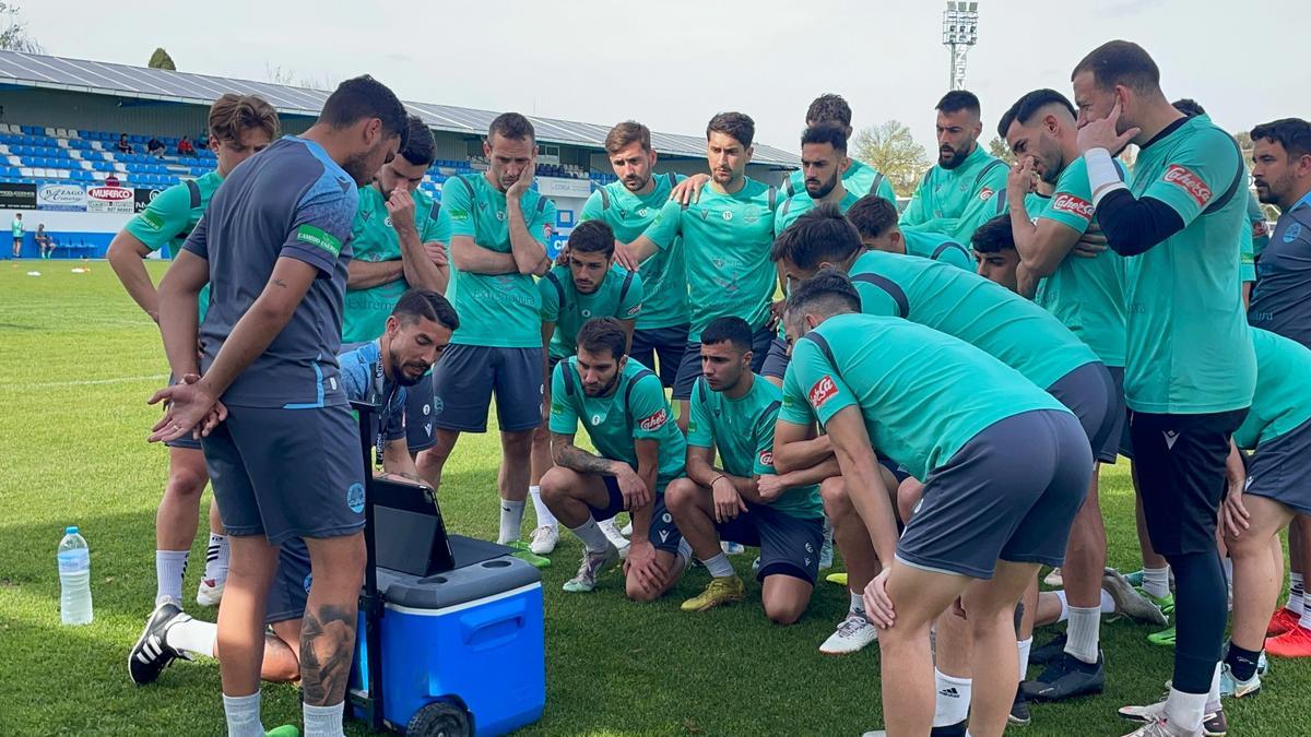 Diego Merino hace indicaciones a sus jugadores apoyándose en las imágenes de un ordenador portátil.