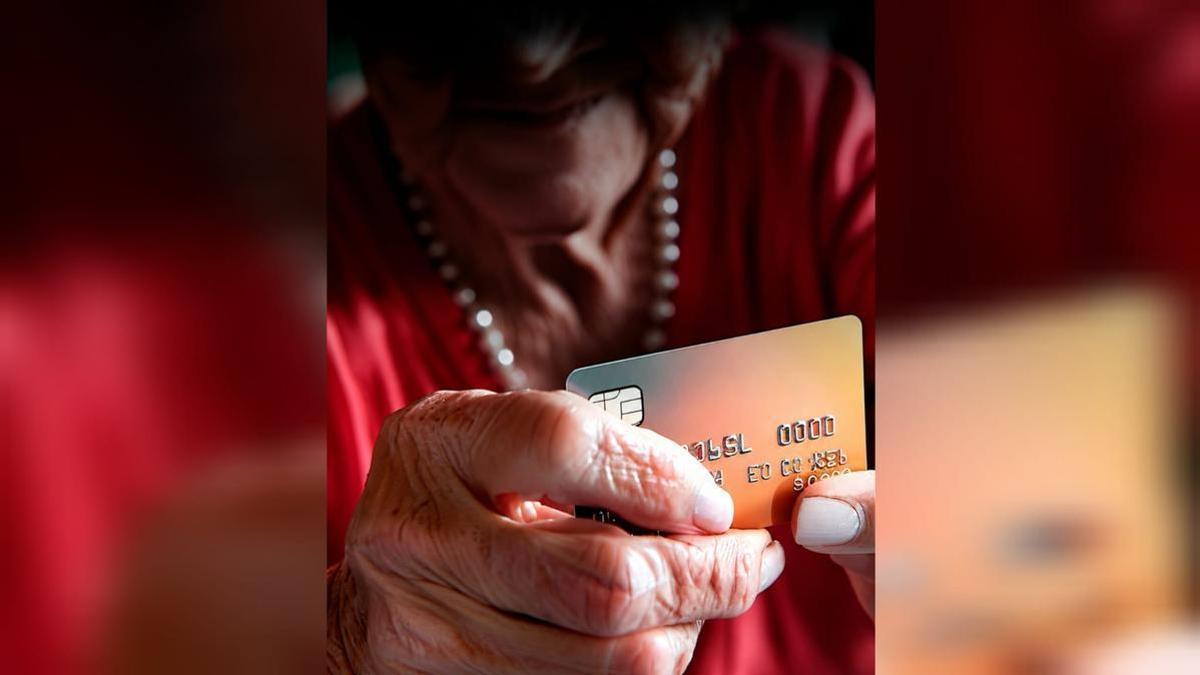 Una mujer mayor utiliza una tarjeta de crédito, en una foto de archivo.