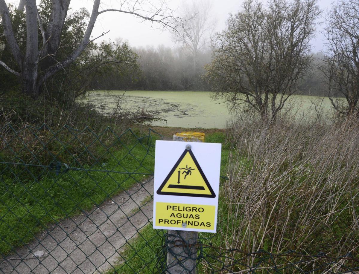 Verja con el cartel de peligro que impide el paso a la Lagoa de Massó .