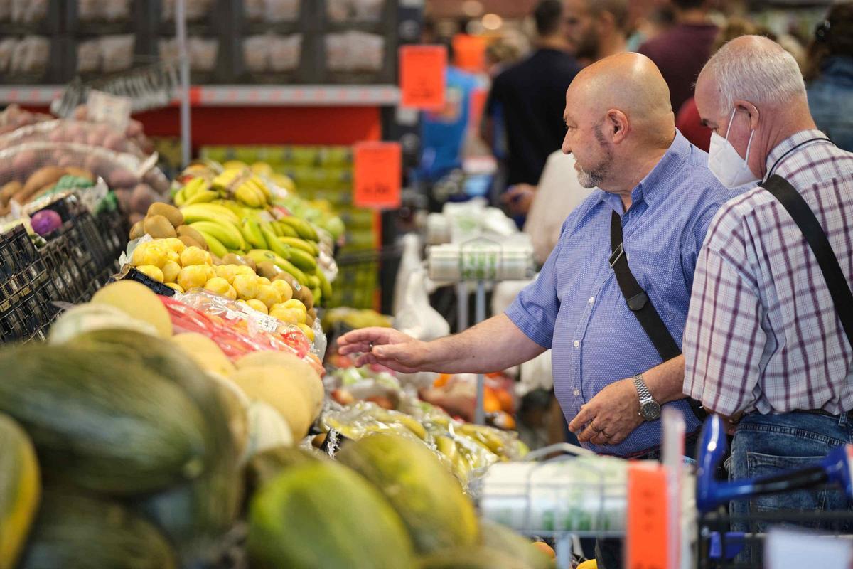 No se esperan bajadas de precios de los alimentos, en general, en 2024; en la imagen, dos hombres miran la fruta de un supermercado.
