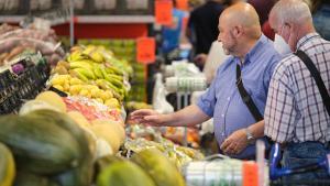 No se esperan bajadas de precios de los alimentos, en general, en 2024; en la imagen, dos hombres miran la fruta de un supermercado.