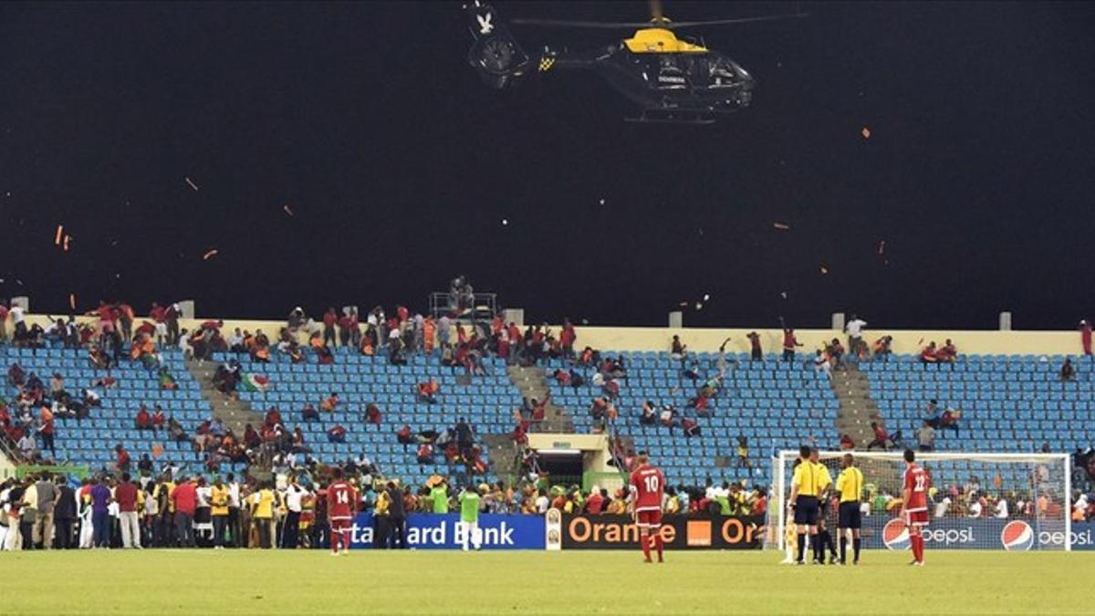 Un helicóptero de la Policía sobrevuela el estadio de Malabo entre una lluvia de objetos