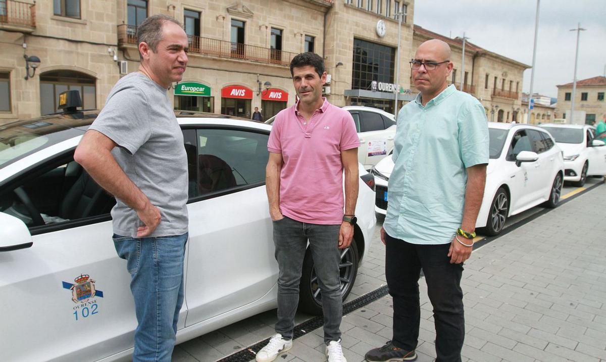 El presidente de los taxistas, en el centro, con otros compañeros en la parada de la estación. |   // IÑAKI OSORIO