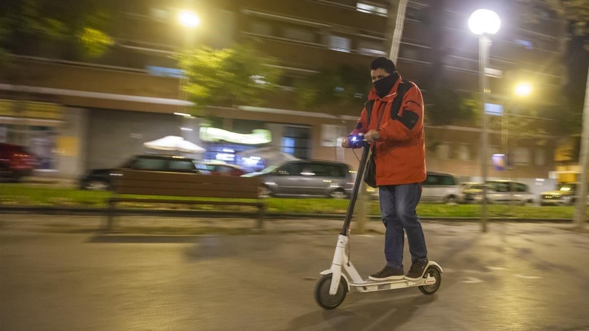 Un joven conduce su patinete por la Rambla del Carme de Esplugues de Llobregat.