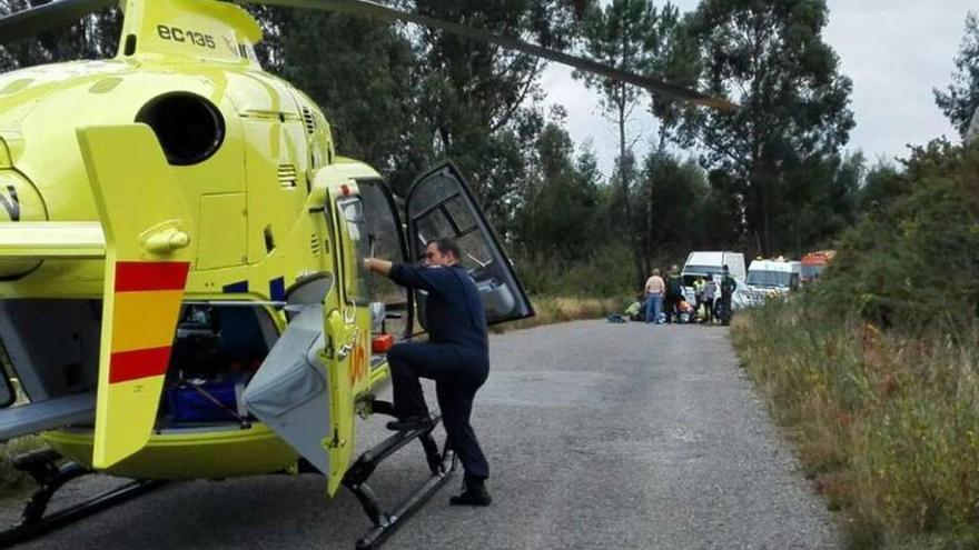 El cazador, atendido en último plano, tras el aterrizaje del helicóptero del 061. // Faro