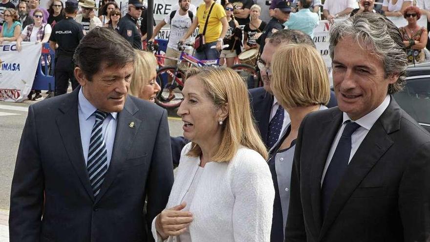 Javier Fernández, a la izquierda, con Ana Pastor e Íñigo de la Serna, a su llegada al recinto ferial, donde fueron recibidos por una sonora pita de trabajadores de empresas en conflicto, al fondo.