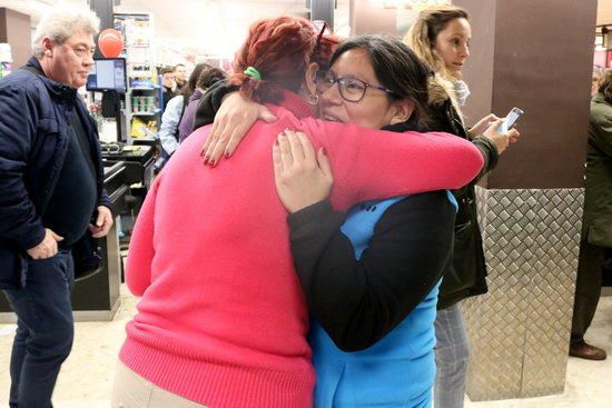 Una guanyadora del primer premi de la Grossa de Cap d'Any abraçant-se amb la cap del supermercat on havia comprat el bitllet.