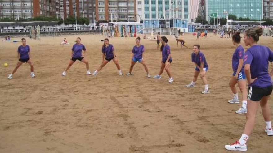 Las jugadoras del Oviedo Balonmano Femenino hacen los estiramientos previos a un entrenamiento en Gijón.