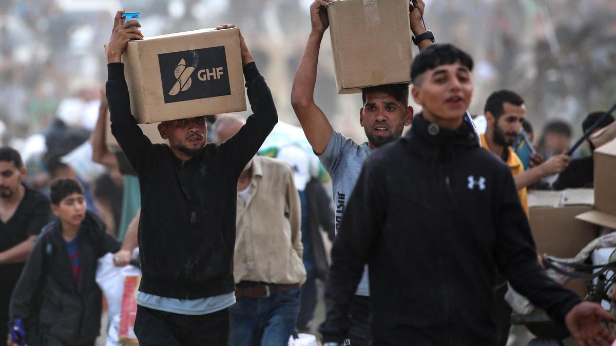 Palestinos cargan cajas con ayuda entregada por la Fundación Humanitaria de Gaza, este domingo en el centro de Gaza.