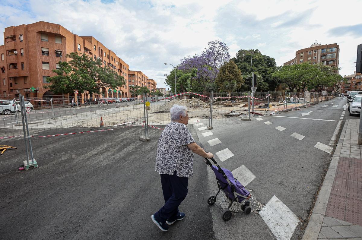 Una mujer pasea con un carrito por la zona en obras de San Blas.