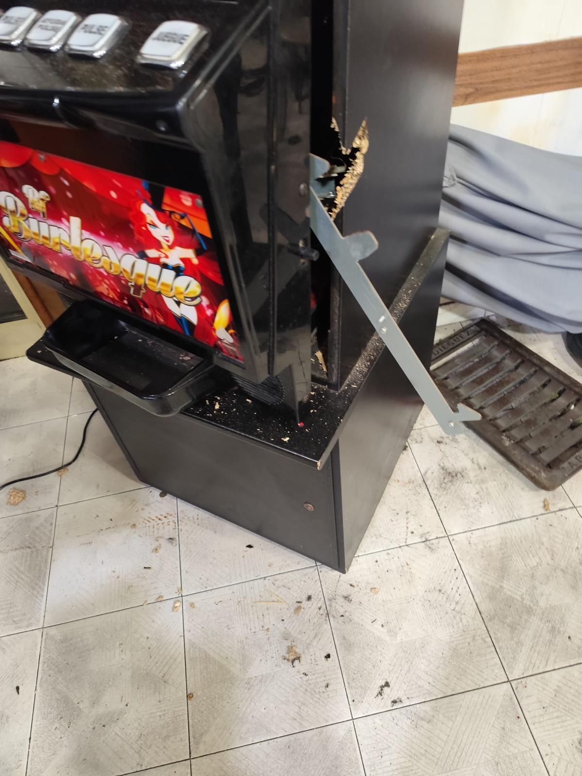 La máquina tragaperra reventada en la confitería, con la tapa de registro utilizada al lado.