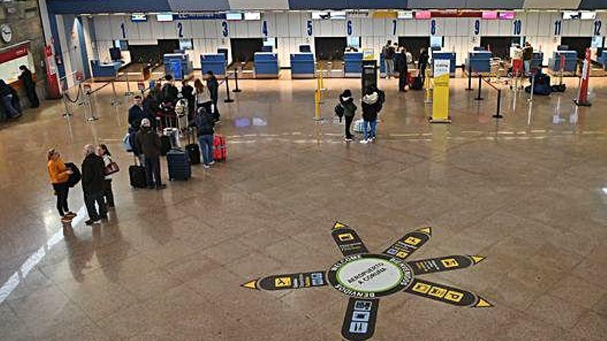 Vestíbulo de la terminal del aeropuerto de Alvedro, con la zona de facturación al fondo.