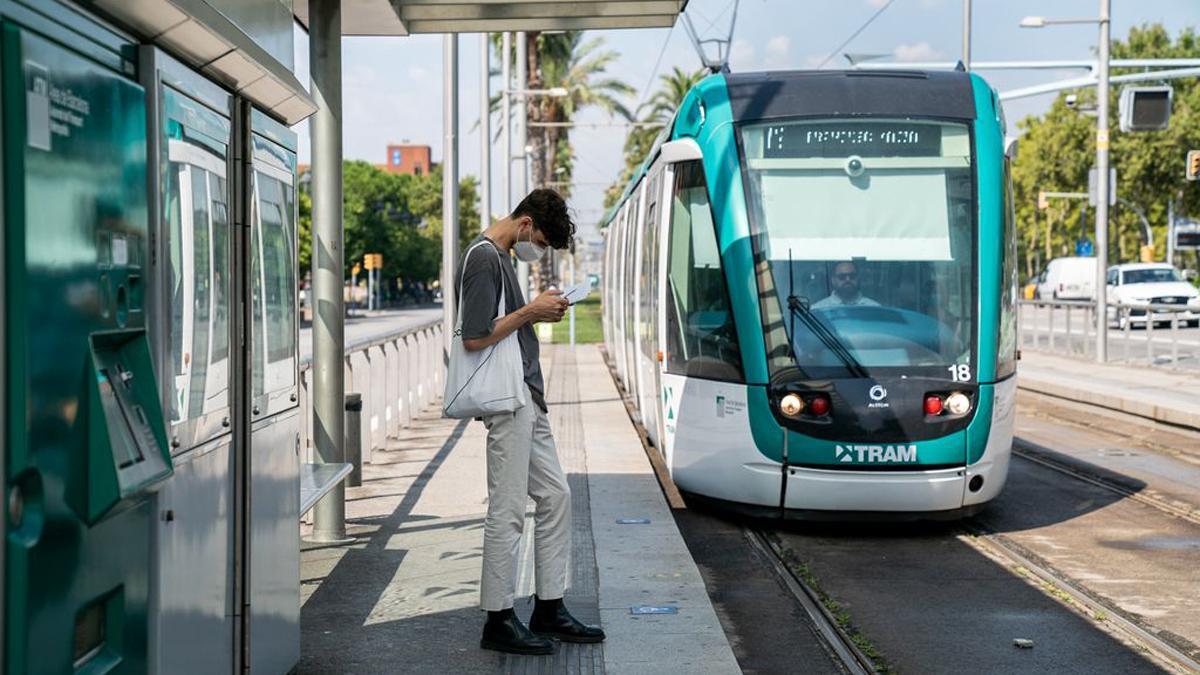 Un joven espera en la parada del tranvía