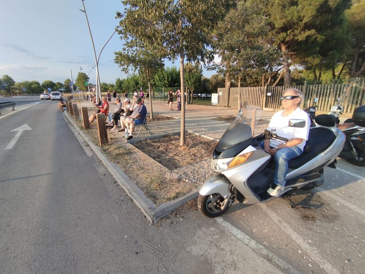 Gent observant l'eclipsi instal·lats a l'aparcament del parc