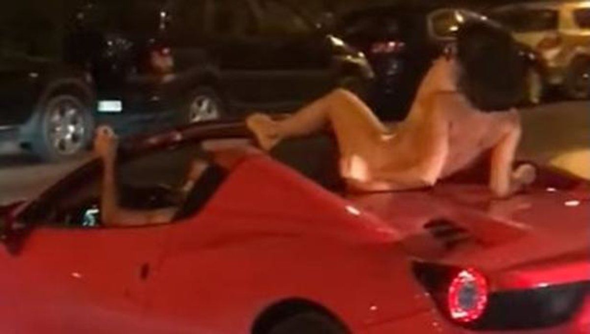 Un hombre conduce en Ibiza un ferrari con una mujer desnuda