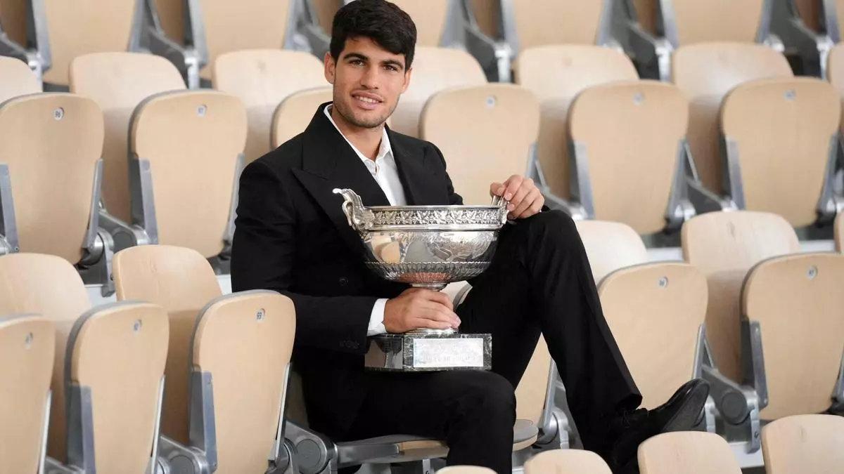 Carlos Alcaraz posa con la Copa de los Mosqueteros de Roland Garros en la grada de la Philippe Chatrier, este lunes.
