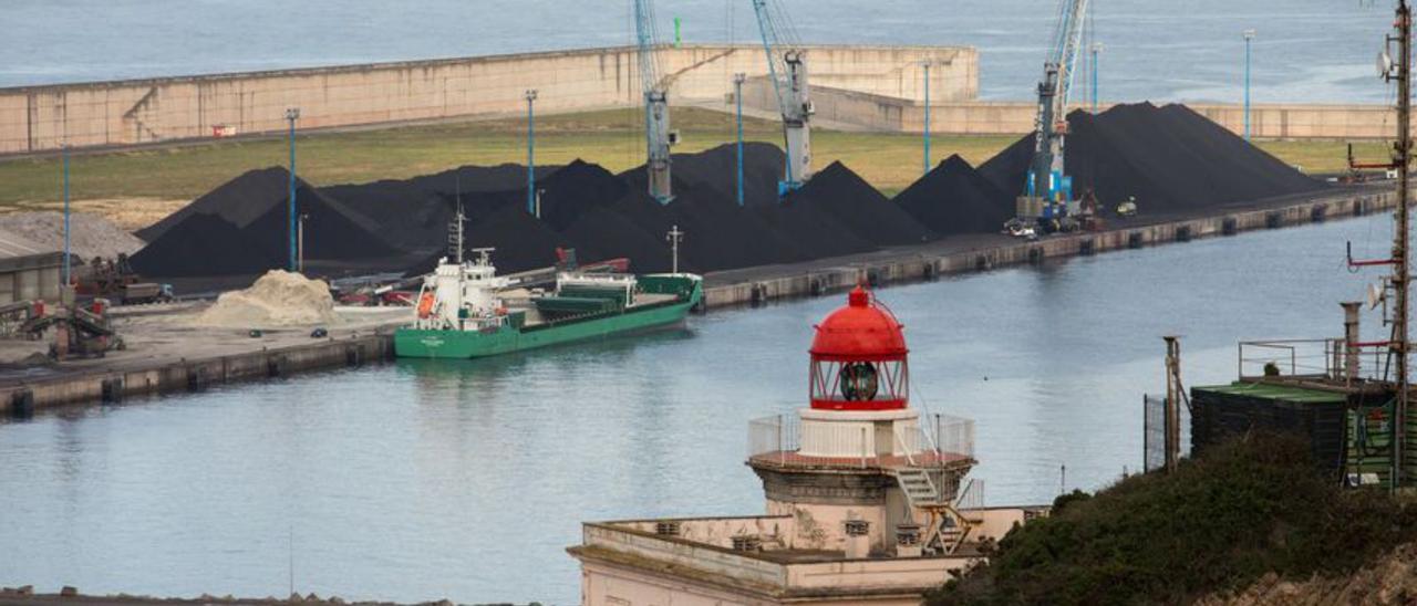 Al fondo, parvas de carbón acopiadas en el Muelle Norte de la ampliación de El Musel el mes pasado. | Juan Plaza