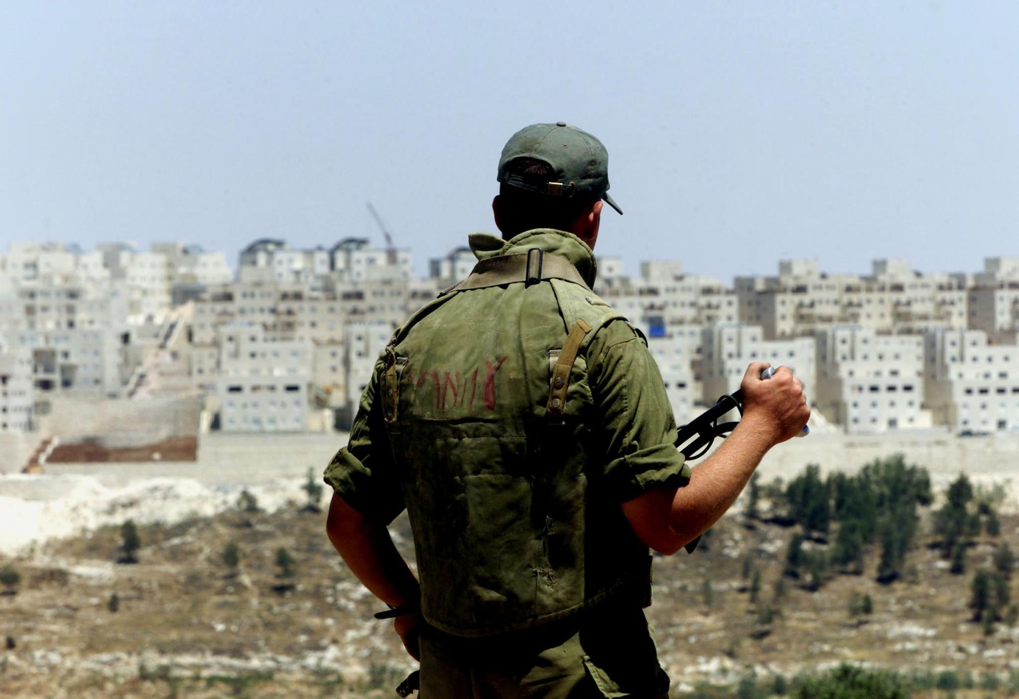 Un soldado israelí vigila un asentamiento ilegal