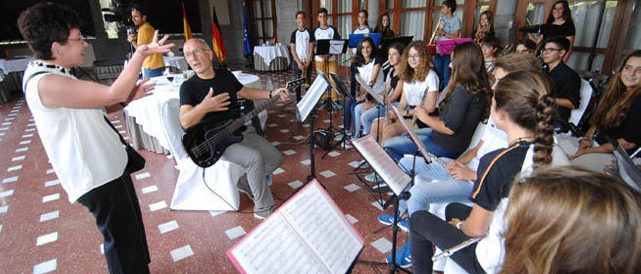 La cónsul Judith Elisa Metz habla con la banda de música durante el cóctel.