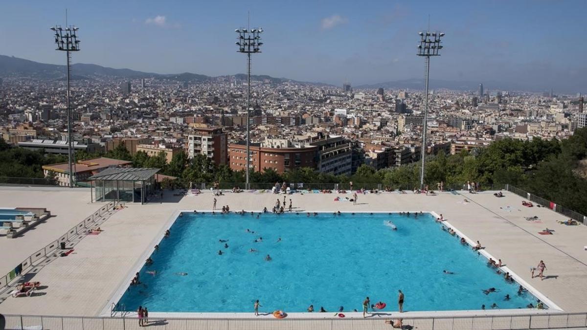 Una pisicina situada en la montaña de Montjuïc, con la ciudad de Barcelona al fondo.