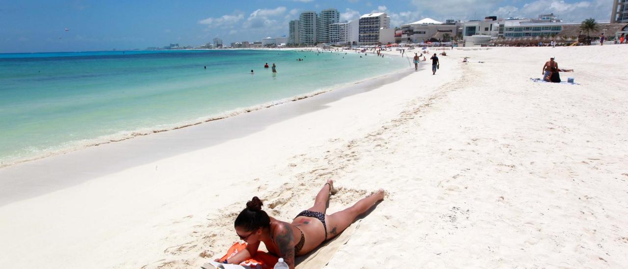 Turistas disfrutan de la playa en el balneario de Cancún, en el caribe mexicano