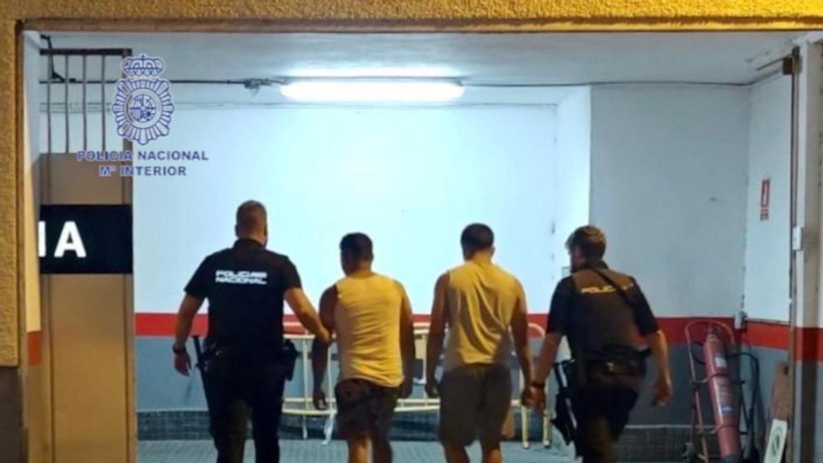 Varios detenidos escoltados por la Policía.