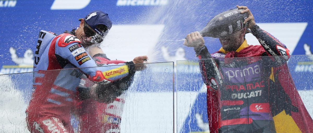 Jorge Martín, a la derecha, ducha con cava a Marc Márquez, en el podio de Le Mans.