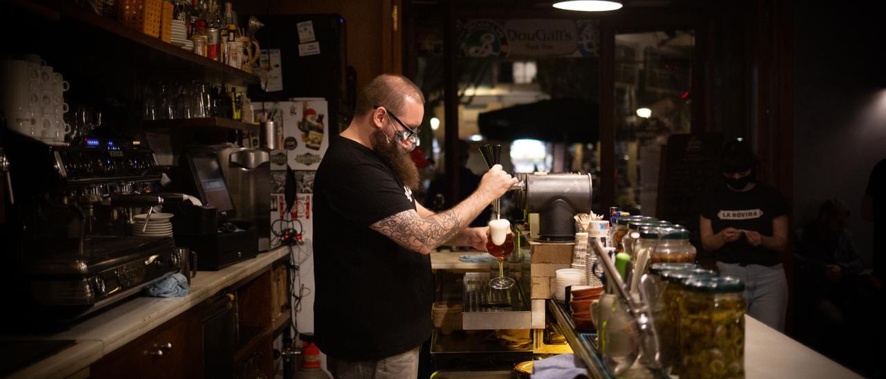 Un camarero sirve una cerveza en el interior de un bar.