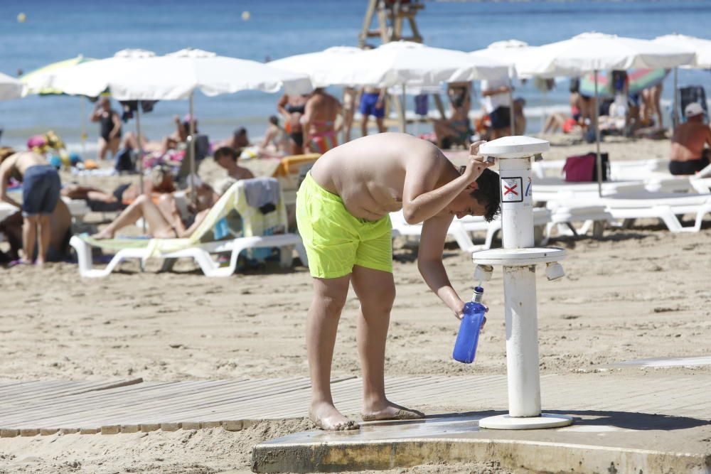 Un joven recoge agua en una de las baterías de un lavapiés playero