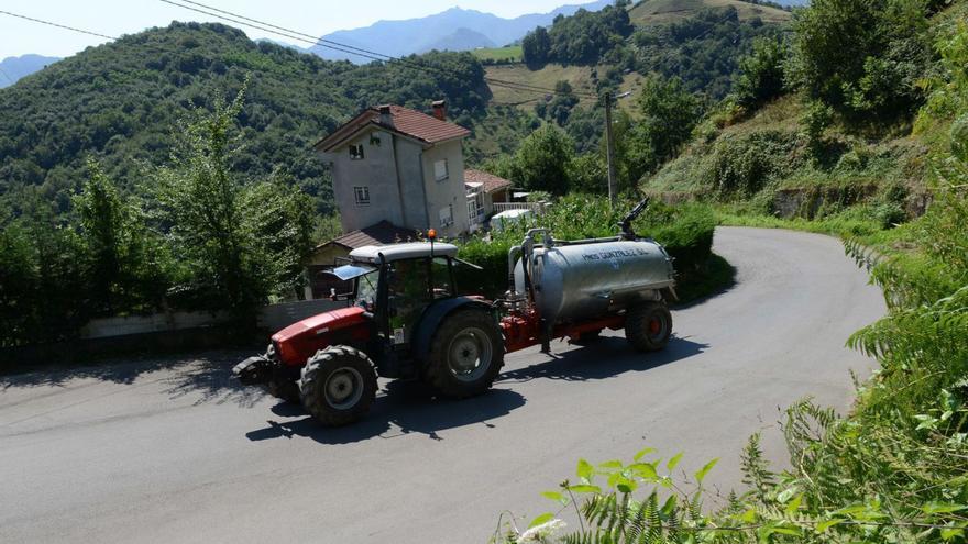 Una cuba de agua pasa por el pueblo de Lloreo, en Laviana, un pasado verano. | LNE