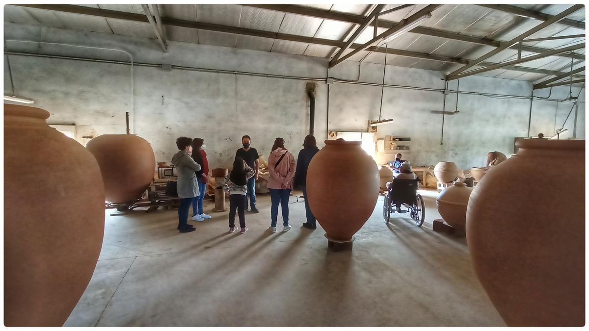 Varias personas en una visita guiada a un taller de artesanía en Torrejoncillo.