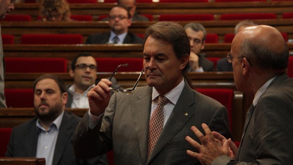 Artur Mas habla con el 'conseller' Boi Ruiz, con Oriol Junqueras al fondo, este jueves.